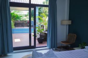 a bedroom with a bed and a view of a patio at House Bok Bowie in Koh Rong Sanloem