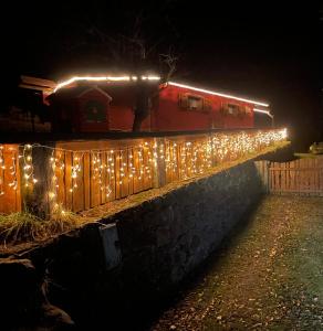 un train avec des lumières sur une clôture la nuit dans l'établissement DOSSENA Splendido Chalet di Montagna immerso nella natura, à Madonna della Costa