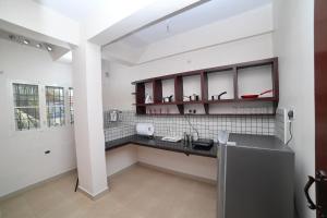 a kitchen with white walls and a black counter at Indeevaram Residency in Trivandrum