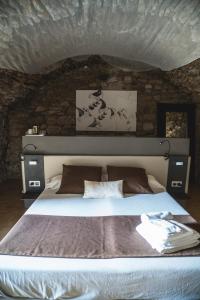 a bedroom with a large bed with a stone wall at Ses Garites in Pals