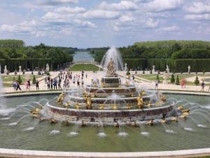 una fuente en un parque con gente caminando alrededor en Appart à Versailles, 2 à 4 pers, avec parking, en Versalles