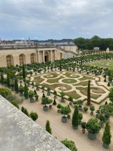 vistas a un jardín con árboles y arbustos en Appart à Versailles, 2 à 4 pers, avec parking, en Versalles