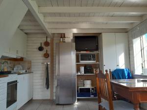 a kitchen with a stainless steel refrigerator and a table at Lotta´s Cottage in Rimbo