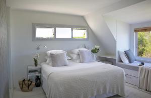 ein weißes Schlafzimmer mit einem Bett mit weißer Bettwäsche und Kissen in der Unterkunft Broad Horizon in Scarborough