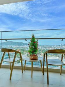 a christmas tree on a table with two chairs at The Song WinHome Apartment in Vung Tau