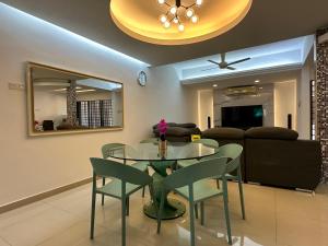 吉隆坡的住宿－KL Sri Petaling BBQ & Games Landed House，一间设有玻璃桌和椅子的用餐室