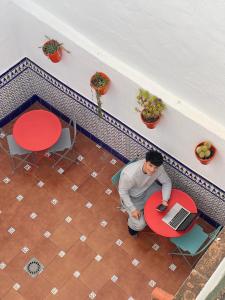 een man aan een rode tafel met een laptop bij Bermeja Village in Marbella