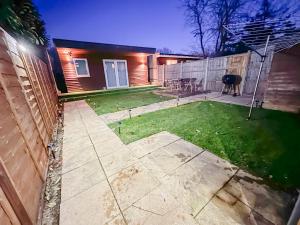 a backyard with a fence and a cow in the yard at Stunning Studio Garden House - Free Wifi & Parking in Hendon