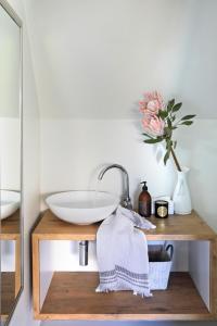 ein Badezimmer mit einem Waschbecken und einer Vase mit einer Blume in der Unterkunft Broad Horizon in Scarborough
