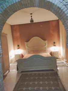 1 dormitorio con 1 cama con 2 mesitas de noche y 2 lámparas en Maison d'hôtes Dar Ranim Tozeur, en Tozeur