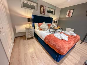 a bedroom with a bed with a blue head board at Stunning Studio Garden House - Free Wifi & Parking in Hendon