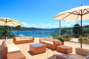 eine Terrasse mit Stühlen und Sonnenschirmen mit Blick auf den Hafen in der Unterkunft Metro Mirage Hotel Newport in Newport