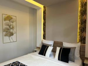 a bedroom with a bed with black and white pillows at Les Fontaines d'O in Castelnau-dʼEstrétefonds