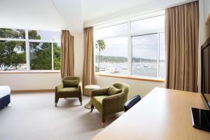 a hotel room with a table and chairs and a large window at Metro Mirage Hotel Newport in Newport