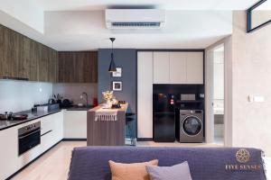 een keuken en een woonkamer met een wasmachine en droger bij Datum Jelatek Residence, KLCC in Kuala Lumpur