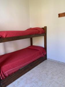 Habitación con 2 literas y sábanas rojas. en Complejo Rincon del Uruguai en Colón