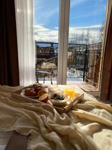 a tray of food on a bed with a window at Sykowny Biały Dunajec in Zakopane