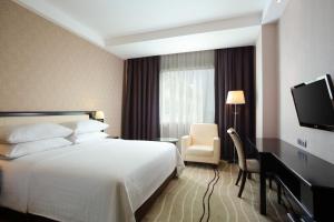 a hotel room with a bed and a television at Four Points by Sheraton Medan in Medan