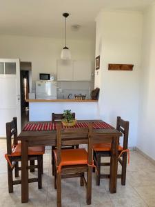 a dining room table with chairs and a kitchen at Complejo Rincon del Uruguai in Colón