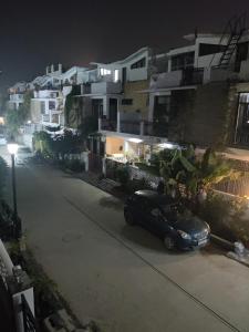un'auto parcheggiata sul lato di una strada di notte di Osho homes a Lucknow