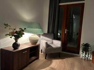 ein Wohnzimmer mit einer Lampe und einem Stuhl in der Unterkunft Hotel Nijeveen in Nijeveen