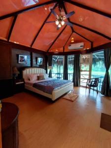 1 dormitorio con 1 cama y ventilador de techo en ChitraResort, en Narail