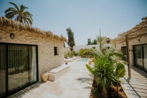 a courtyard of a house with plants and a building at Hotel Anilevich Mansion in Beer Sheva