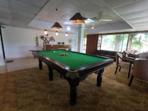 een biljartkamer met een groene pooltafel bij ChitraResort in Narail