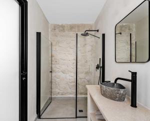 a bathroom with a sink and a glass shower at Hotel Anilevich Mansion in Beer Sheva