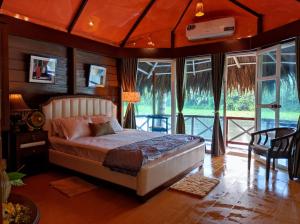 a bedroom with a bed in a room with windows at ChitraResort in Narail