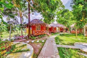 une maison au milieu d'un jardin arboré dans l'établissement ChitraResort, à Narail