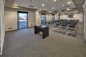 uma sala de conferências com filas de cadeiras e uma mesa em City Express by Marriott Matamoros em Matamoros