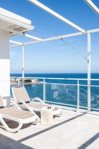 einen Balkon mit Stühlen und Meerblick in der Unterkunft Maria Paola penthouse aan het strand in Fuengirola