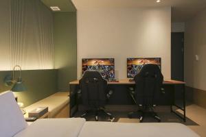 a room with two desks with two computer monitors at Hotel Aria in Cheonan
