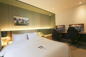 um quarto de hotel com uma cama e dois monitores em Hotel Aria em Cheonan