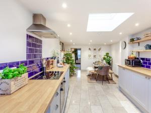 a large kitchen with blue tiles on the wall at The Old Smithy in West Ashton