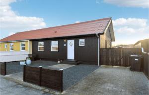 une maison noire avec une porte blanche et une clôture dans l'établissement Amazing Home In Skagen With Kitchen, à Skagen