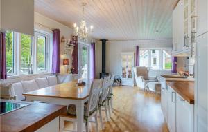 Cozy Home In Uddevalla With House A Panoramic View في Sundsandvik: مطبخ وغرفة معيشة مع طاولة وكراسي