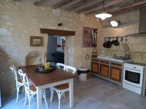 a kitchen with a wooden table and white appliances at Gite Nuance in Saint-Aignan