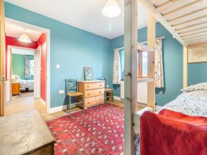 New Buckenham的住宿－聖瑪麗禮拜堂度假屋，一间卧室设有蓝色的墙壁、一张床和一张书桌