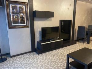 Una sala de estar con un televisor de pantalla plana y una mesa. en Мия 2 Deluxe Royal Spa, en Velingrad
