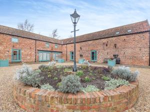 un jardín frente a un edificio de ladrillo con luz de la calle en The Barn - Uk44514, en Tetney