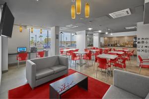 a restaurant with red chairs and tables and a bar at City Express Junior by Marriott Mexicali in Mexicali