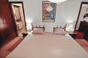 a large bed in a room with a poster on the wall at Charmant appartement avec vue sur les montagnes in Crans-Montana