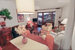 a living room with a couch and a table at Charmant appartement avec vue sur les montagnes in Crans-Montana