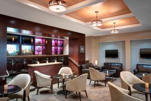 a restaurant with tables and chairs and a bar at Sheraton Houston Brookhollow in Houston