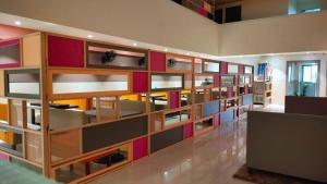 a library with wooden shelving with different colored shelves at Hotel Sai Nidhi Executive-MindSpace Airoli Navi Mumbai in Navi Mumbai