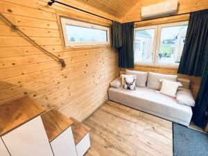 a room with a couch in a tiny house at Tiny House Village (850m od Suntago) in Grabce-Towarzystwo
