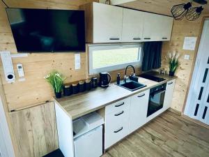 a kitchen with a sink and a tv in a caravan at Tiny House Village (850m od Suntago) in Grabce-Towarzystwo