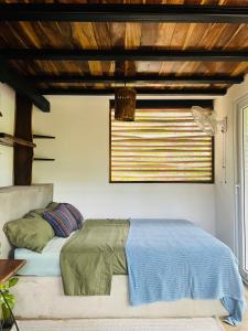 a bedroom with a bed and a window at Agora at Playa Maderas - Surf House, Cabanas and Casitas in Playa Maderas